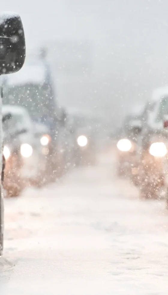 Car traffic jam on busy highway caused by heavy snowfall and cold weather