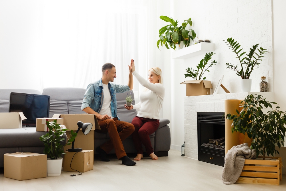 Young couple decorating their rented home with plants
