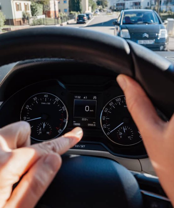 Woman's fingers pointing at the odometer of her vehicle to check the mileage - Acceptance, cheap auto insurance
