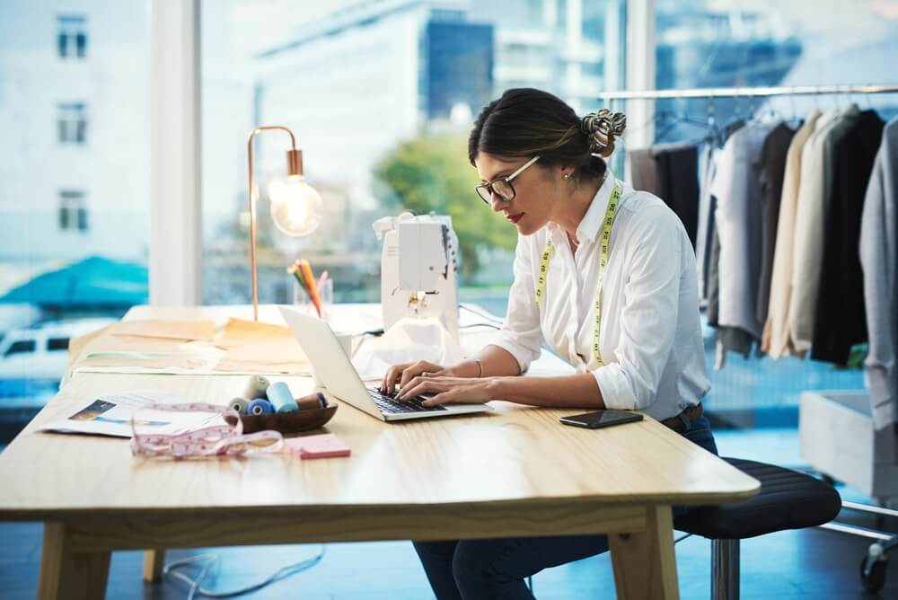 Fashion designer woman in front of her laptop working on her small business for textile in boutique - Acceptance, cheap auto insurance