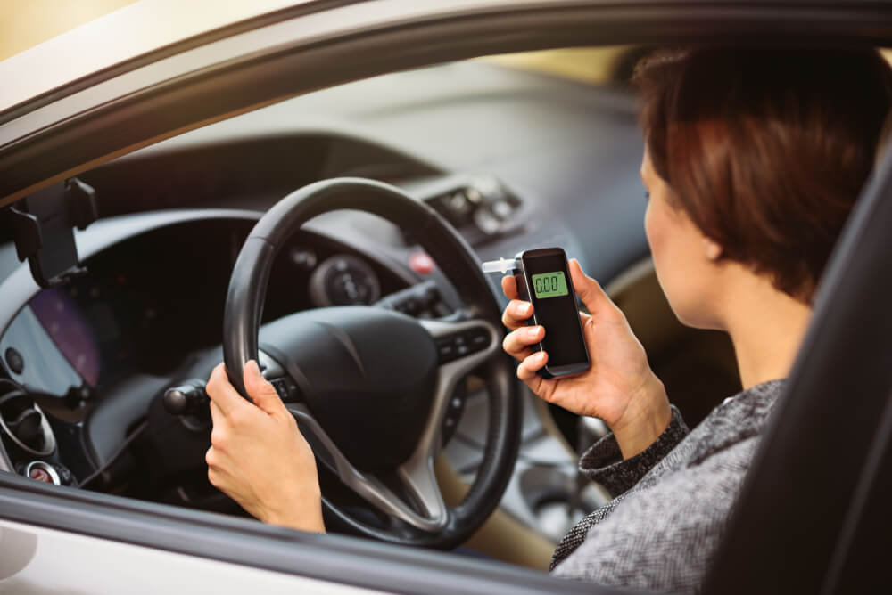 Woman looking at her breathalyzer before driving.