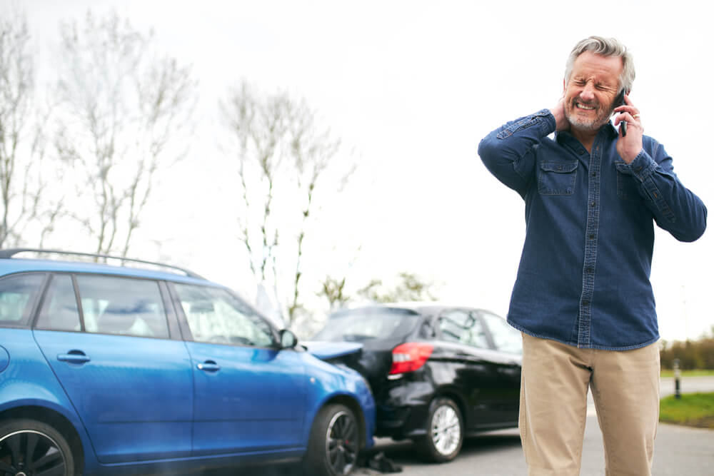 An older man suffering from whiplash after he was hit from behind by another car - cheap uninsured motorist coverage.