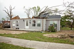 Home after a tornado with half roof missing.