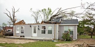 Home after a tornado with half roof missing.