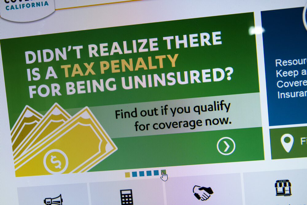 A sign with messages about avoiding a tax penalty by getting health insurance in California through Covered California.