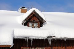 Roof of a home covered in a thick layer of snow - cheap home insurance.