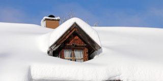 Roof of a home covered in a thick layer of snow - cheap home insurance.