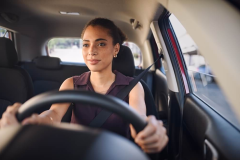 Smiling business woman driving car in city streets - Acceptance