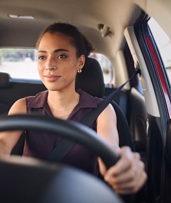 Smiling business woman driving car in city streets - Acceptance