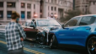 Two men look at the collision their cars have just had.