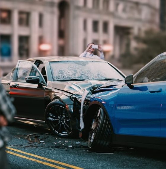 Two men look at the collision their cars have just had.