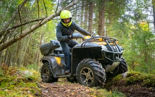 Journey through the forest on a Quad bike. A man rides a Quad bike on the road – cheap ATV insurance.