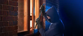 Burglar Using Crowbar To Break Into a House at night