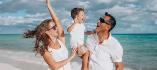 Happy family on vacation on beach on Mexico traveling with Mexican car insurance.