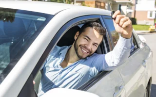 Mexican man happily driving across the border with Mexican auto insurance.