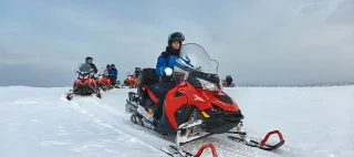 Riding on a snowmobile in Finland, female rider above the Arctic Circle